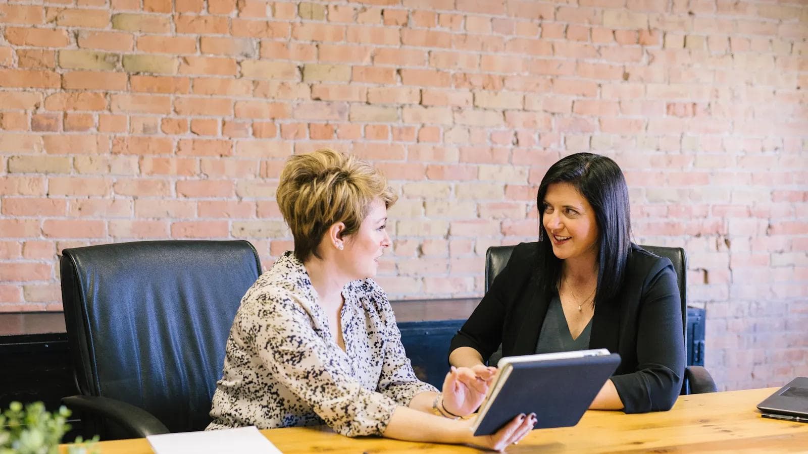 Field sales colleagues reviewing digital meeting notes together after a customer visit